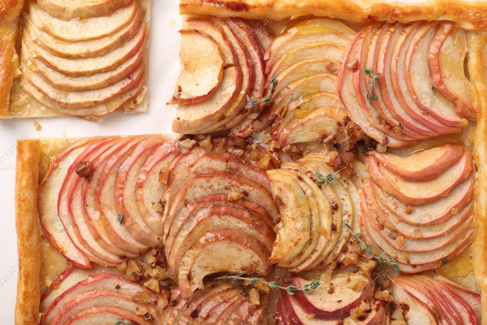 Photo of Freshly baked apple pie with nuts on white table, top view