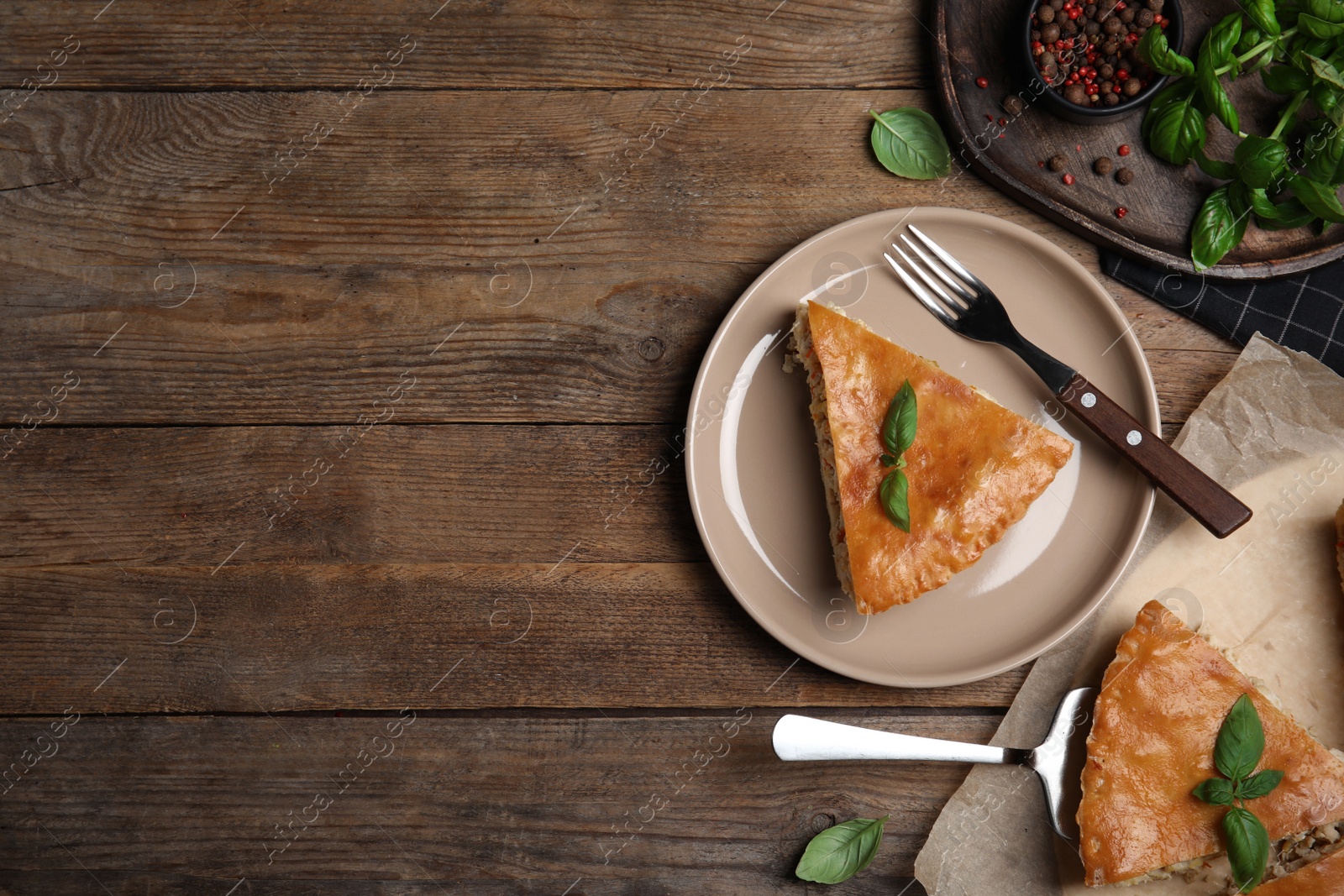 Photo of Delicious pie with meat and basil on wooden table, flat lay. Space for text