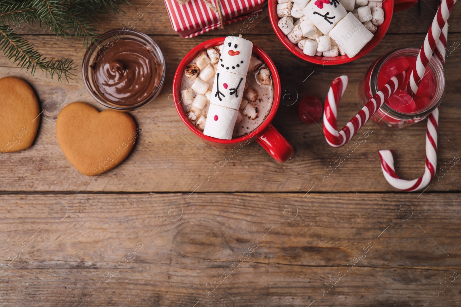 Photo of Flat lay composition with marshmallow snowmen on wooden table. Space for text