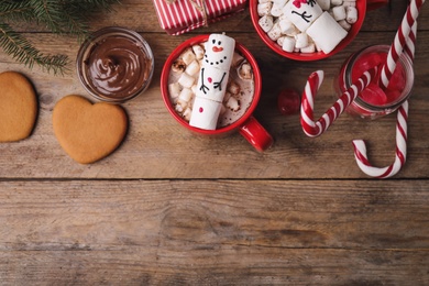 Photo of Flat lay composition with marshmallow snowmen on wooden table. Space for text