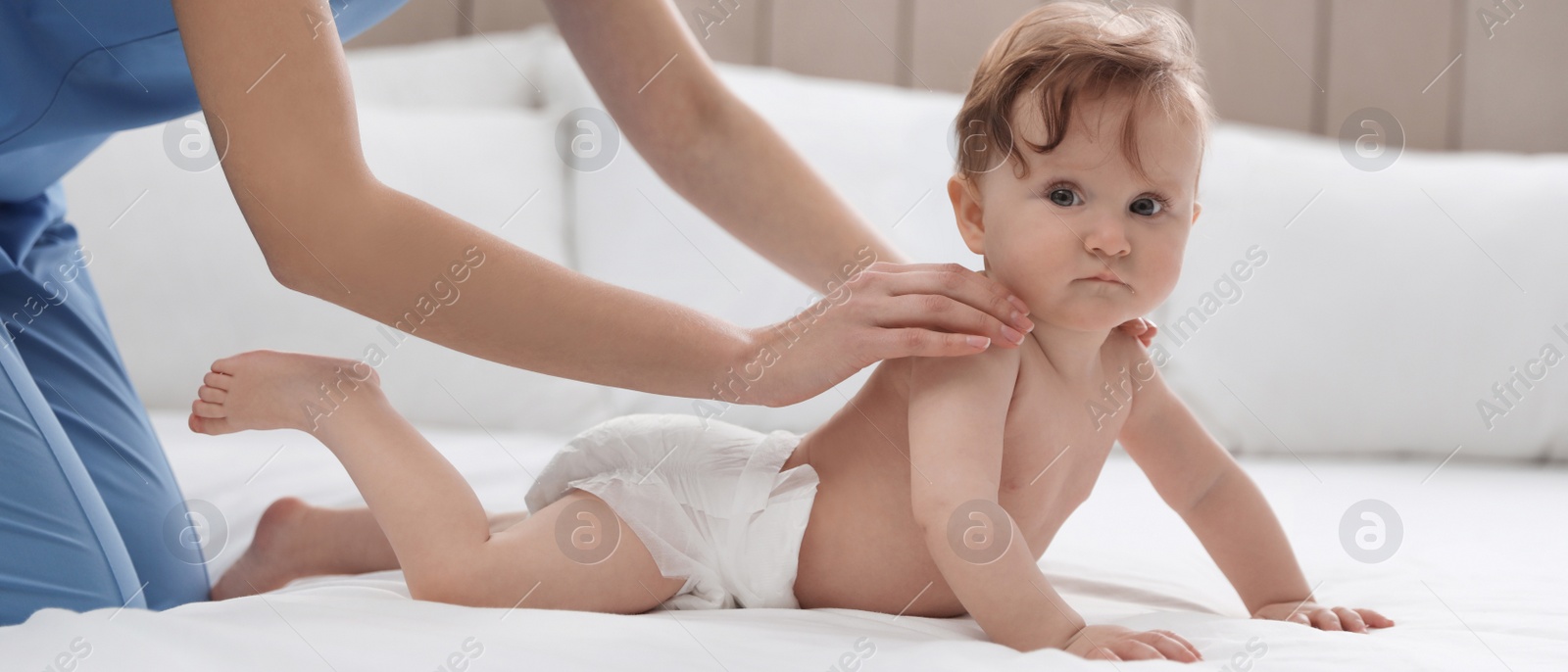 Image of Young nanny and cute baby on white bed at home. Banner design 