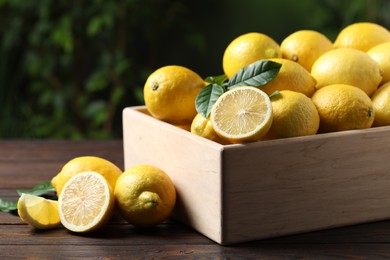 Fresh lemons in crate on wooden table