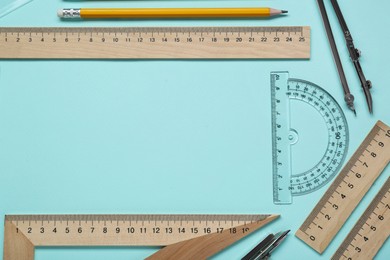 Photo of Flat lay composition with different rulers and protractor on turquoise background. Space for text