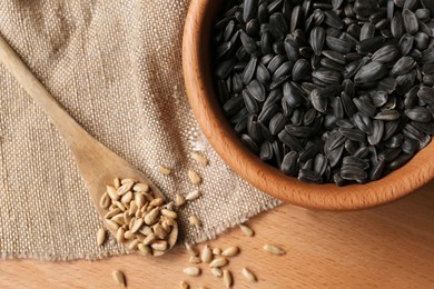 Photo of Organic sunflower seeds on wooden table, flat lay