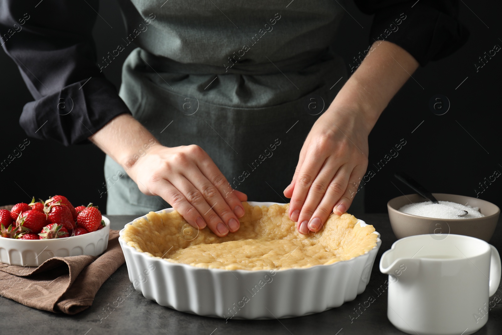 Photo of Shortcrust pastry. Woman making pie at grey table, closeup