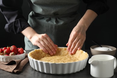 Shortcrust pastry. Woman making pie at grey table, closeup