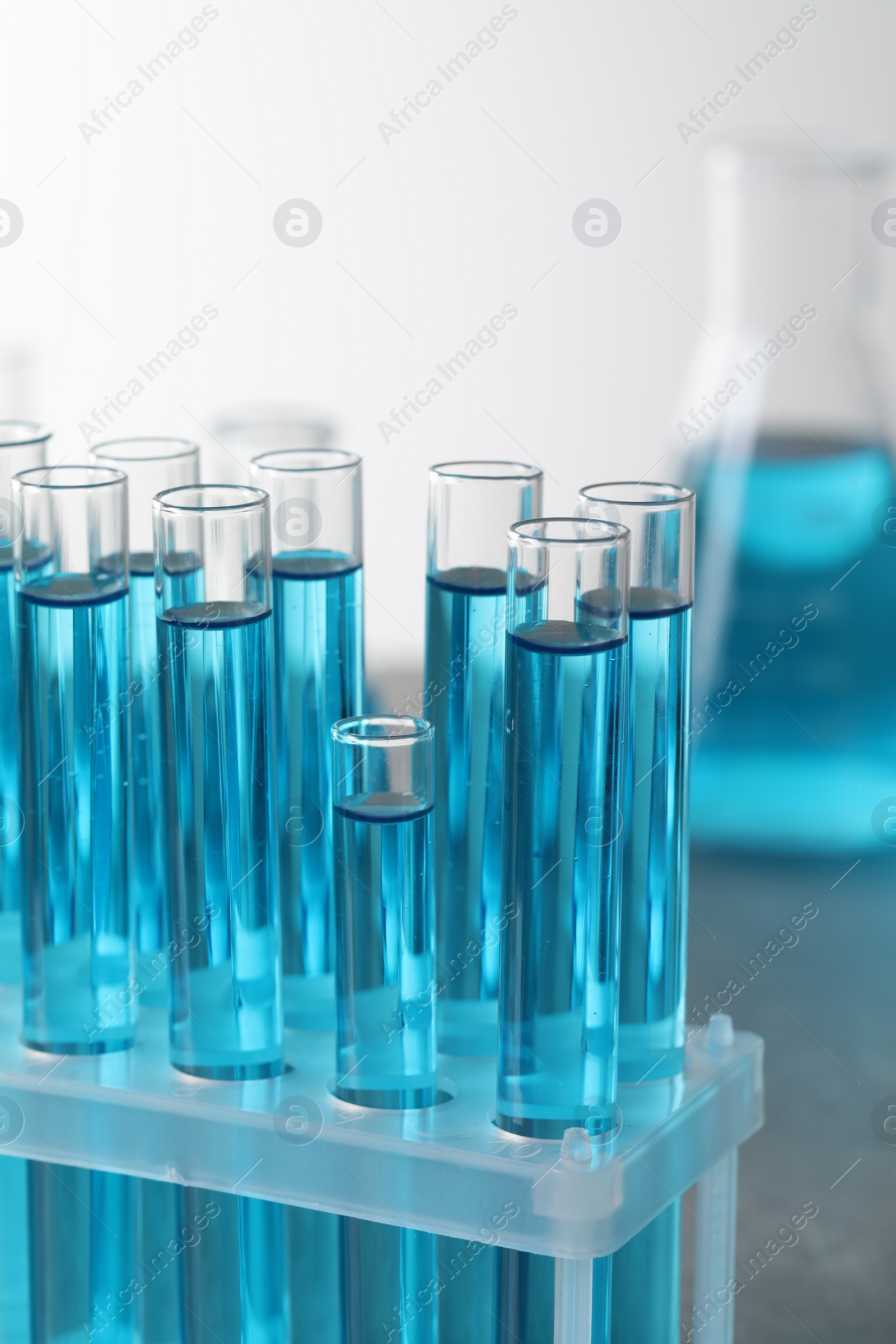 Photo of Test tubes with light blue liquid in laboratory, closeup