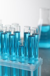 Test tubes with light blue liquid in laboratory, closeup