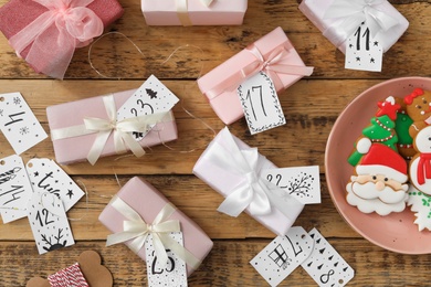 Photo of Flat lay composition with gift boxes and Christmas cookies on wooden table. Creating advent calendar