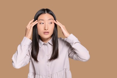 Photo of Portrait of beautiful young Asian woman in stylish outfit on beige background, space for text
