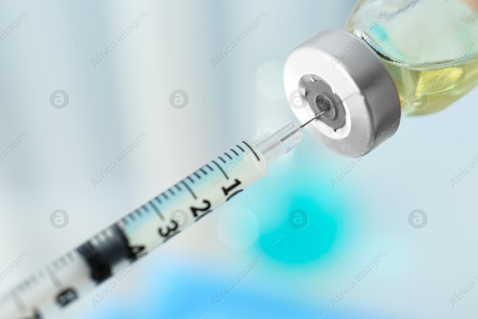 Photo of Filling syringe with vaccine on blurred background, closeup