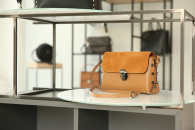 Photo of Stylish woman's bag on stand in boutique