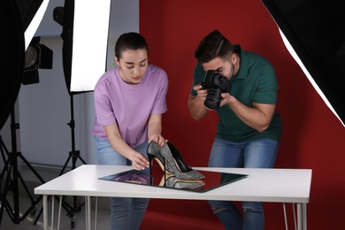 Professional photographers shooting stylish shoes in studio