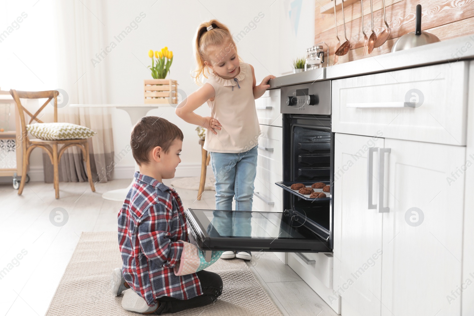 Photo of Little kids baking cookies in oven at home