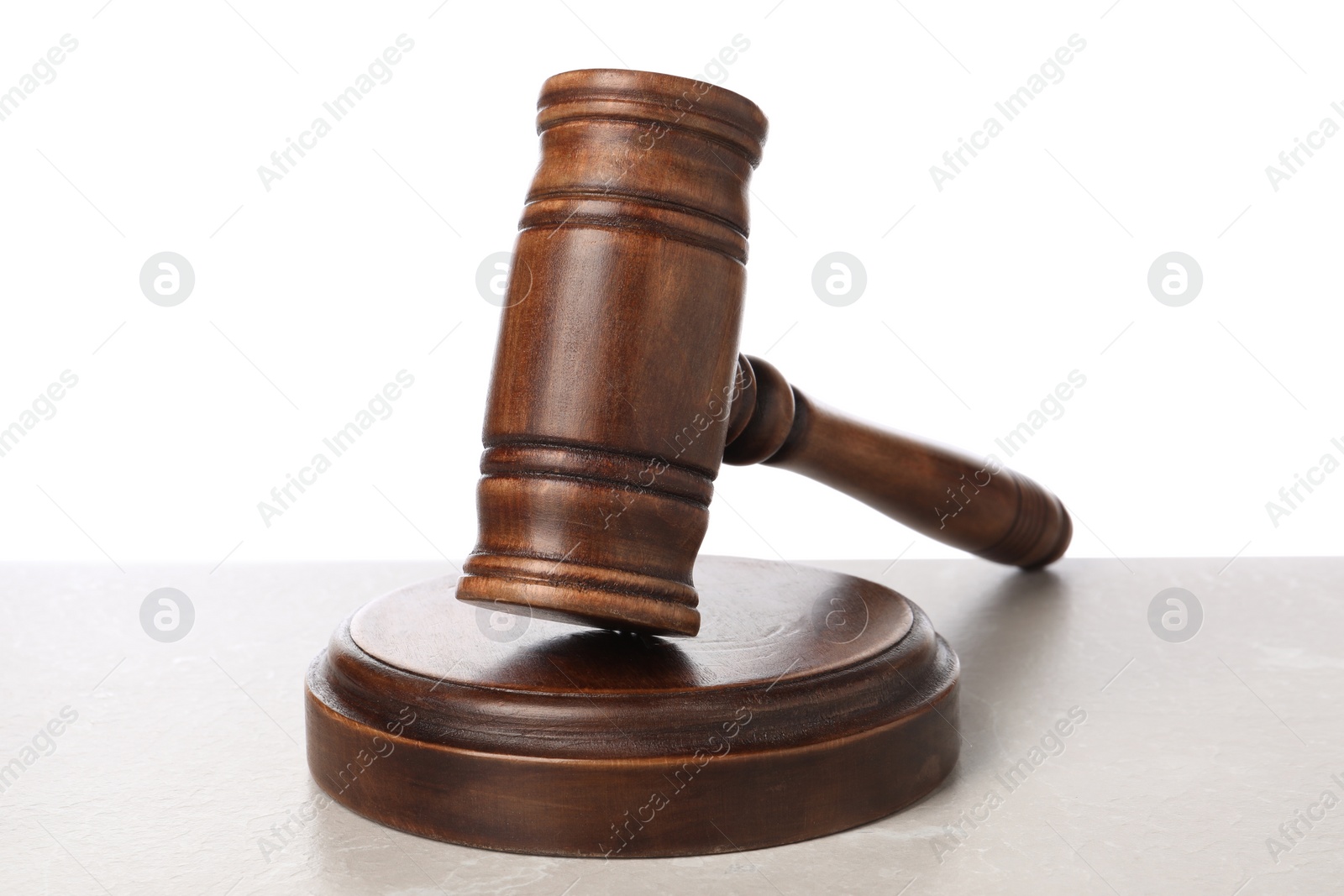 Photo of Wooden gavel on light table against white background