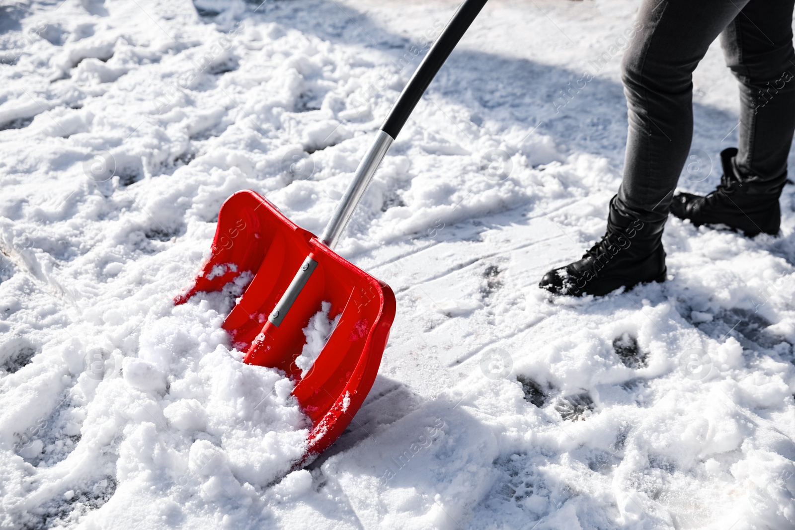 Photo of Person shoveling snow outdoors on winter day, closeup