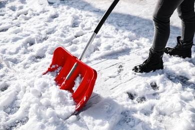 Person shoveling snow outdoors on winter day, closeup