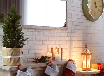 Photo of Christmas tree and fireplace with stockings indoors. Idea for stylish interior design
