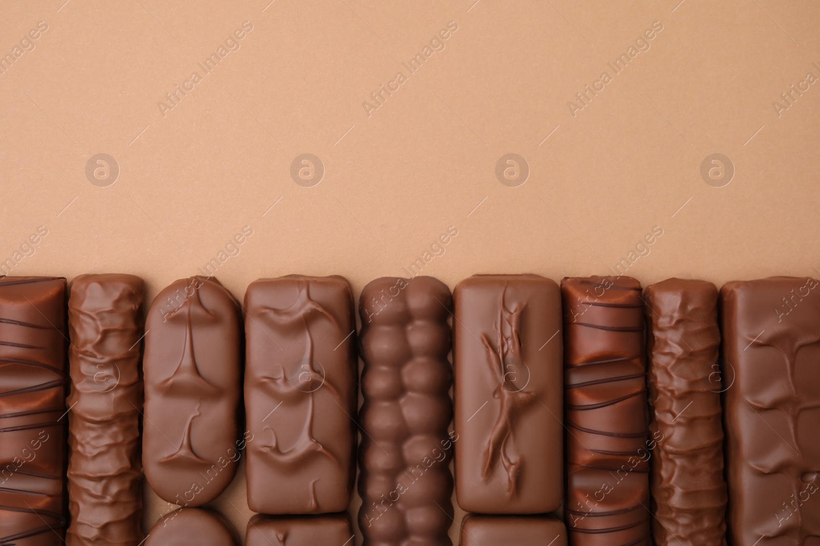 Photo of Different tasty chocolate bars on beige background, flat lay. Space for text