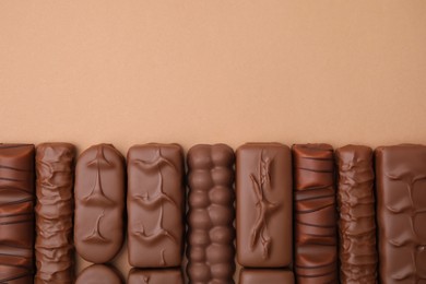 Photo of Different tasty chocolate bars on beige background, flat lay. Space for text