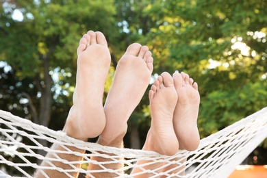 Photo of Young couple resting in hammock outdoors. Summer vacation