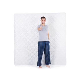 Photo of Young man with comfortable mattress isolated on white