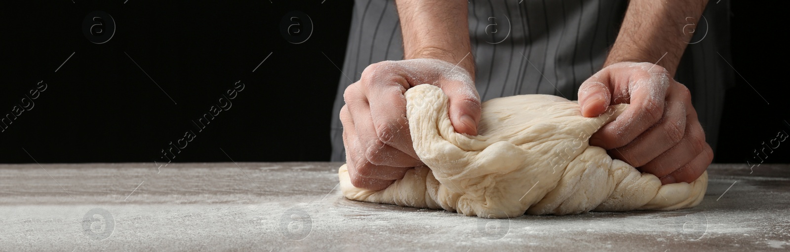 Image of Baker kneading dough at table, closeup. Banner design with space for text