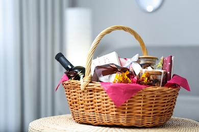 Photo of Wicker basket full of gifts in living room