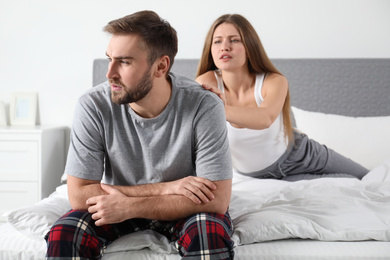 Photo of Young couple with relationship problems in bedroom