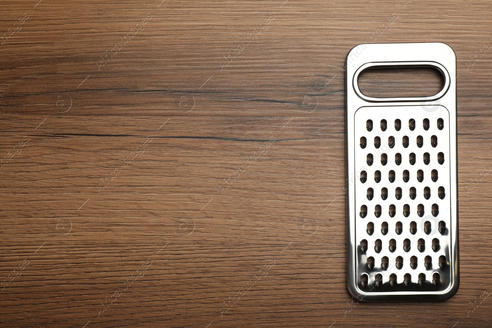 Photo of Modern grater on wooden table, top view. Space for text