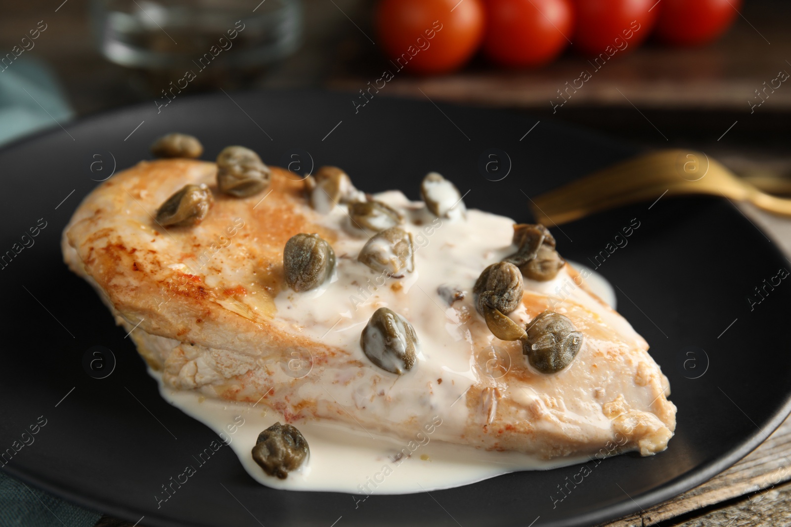 Photo of Delicious chicken fillet with capers and sauce on plate, closeup