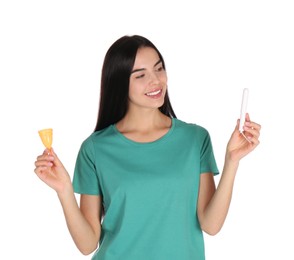 Young woman with menstrual cup and tampon on white background