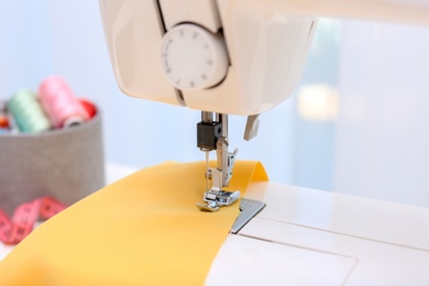 Photo of Modern sewing machine on light background, closeup