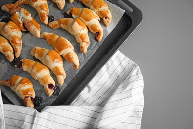 Photo of Baking sheet with tasty croissants on table, top view