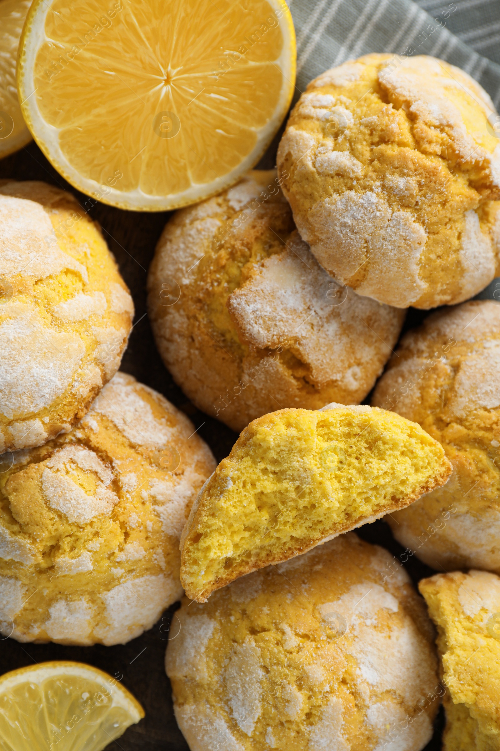 Photo of Delicious lemon cookies and citrus fruit on towel, closeup