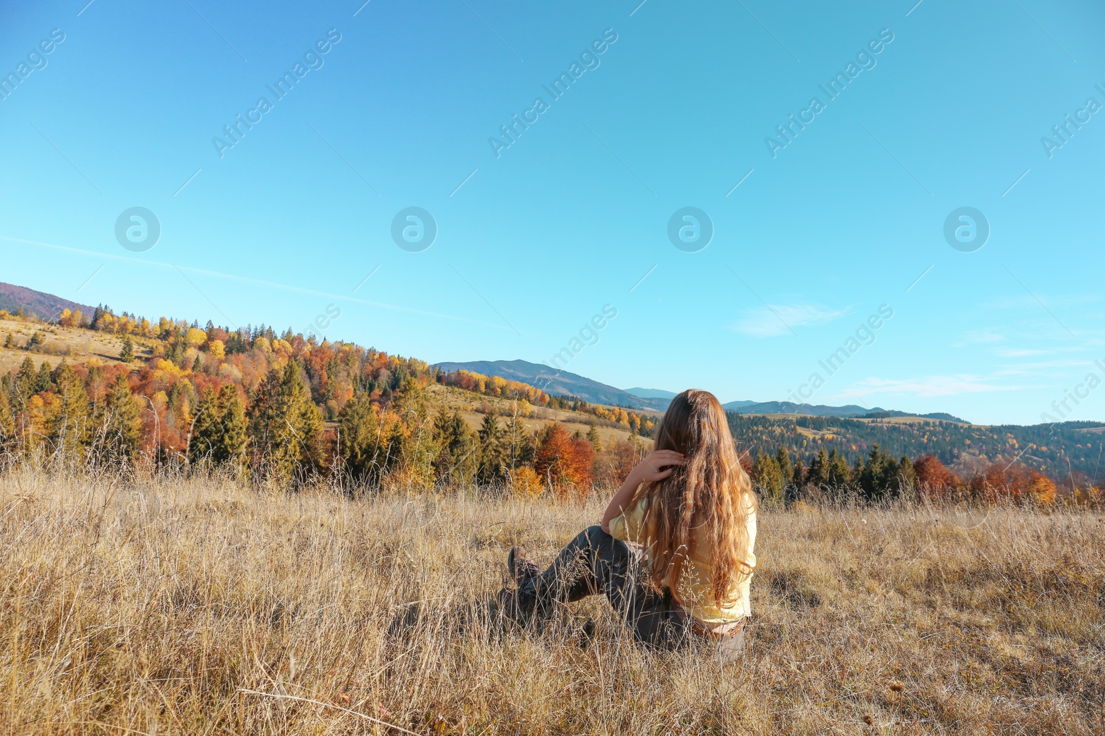 Photo of Female traveler viewing peaceful mountain landscape