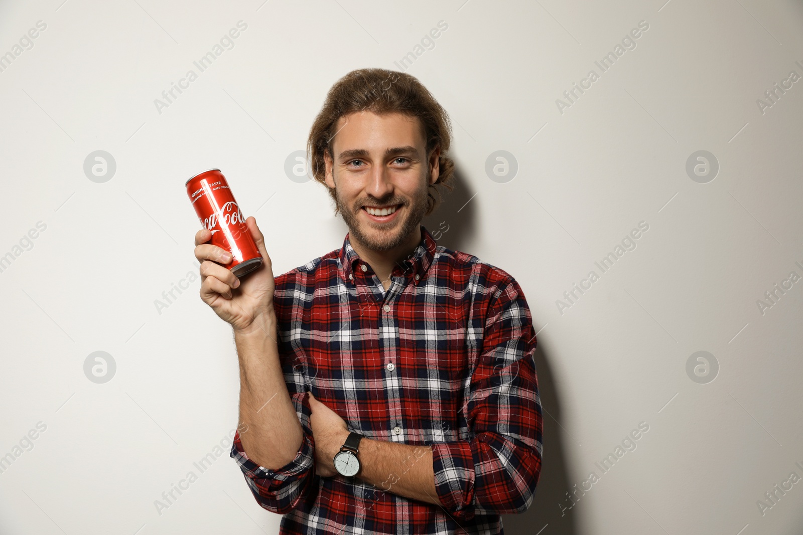 Photo of MYKOLAIV, UKRAINE - NOVEMBER 28, 2018: Young man with Coca-Cola can on white background