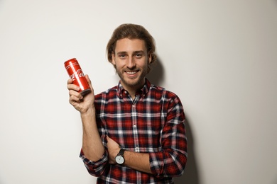 Photo of MYKOLAIV, UKRAINE - NOVEMBER 28, 2018: Young man with Coca-Cola can on white background