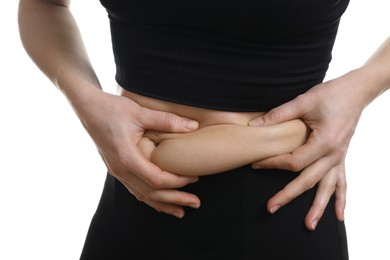 Woman touching belly fat on white background, closeup. Overweight problem