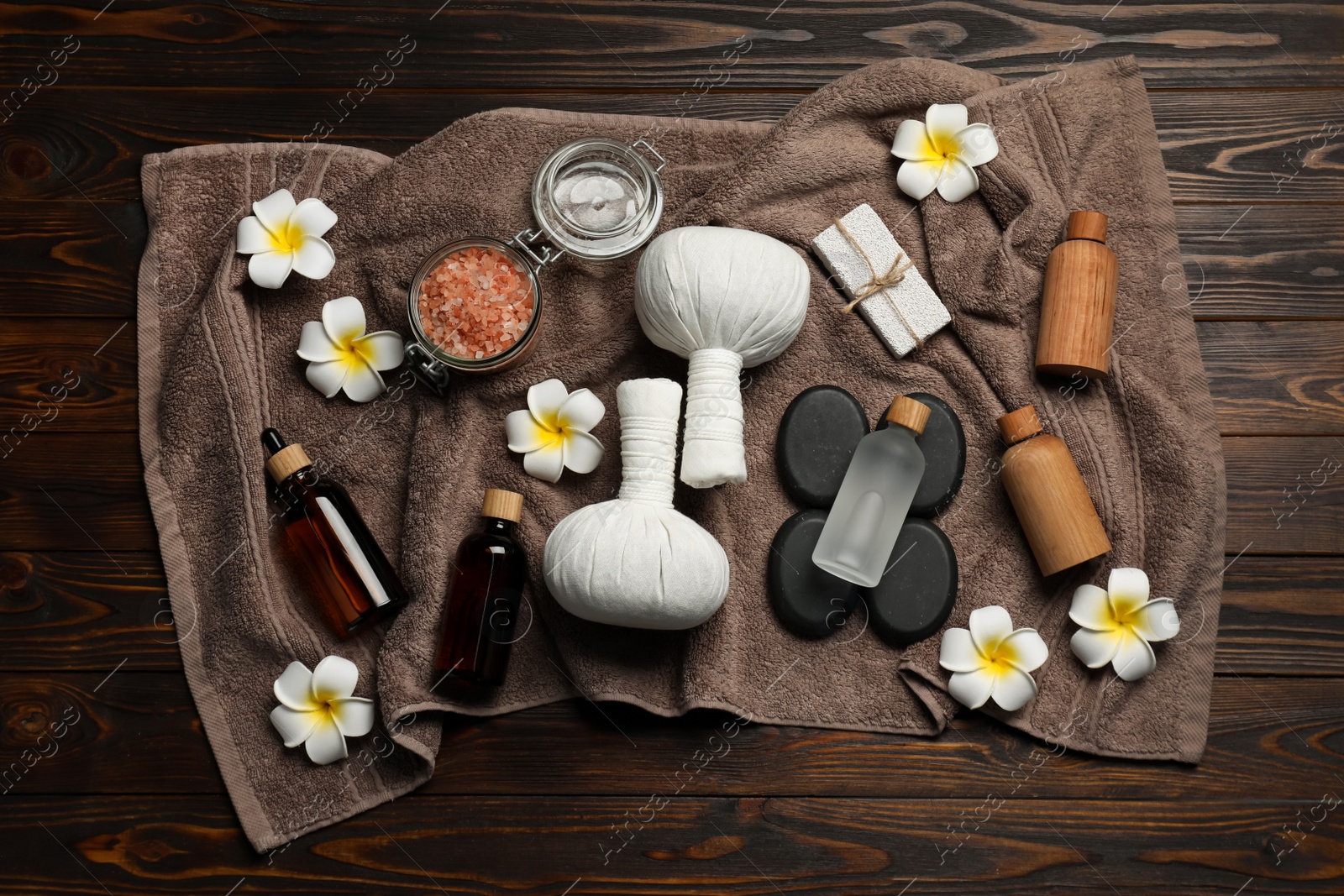 Photo of Composition with herbal massage bags and other spa products on wooden table, top view