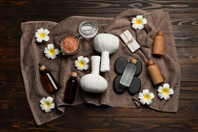 Photo of Composition with herbal massage bags and other spa products on wooden table, top view