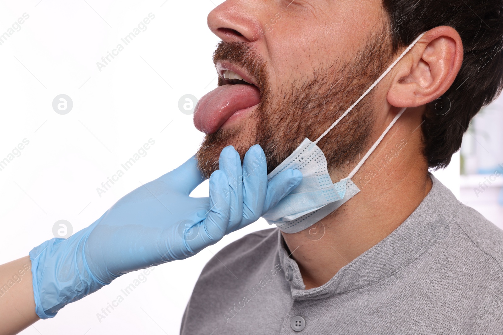 Photo of Doctor examining man`s oral cavity on white background, closeup