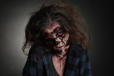 Photo of Scary zombie on dark background. Halloween monster