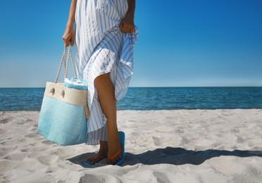 Photo of Woman with beach bag near sea on sunny day, closeup. Space for text