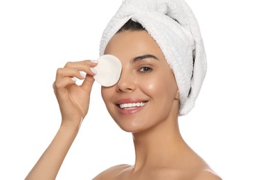 Young woman using cotton pad with micellar water on white background