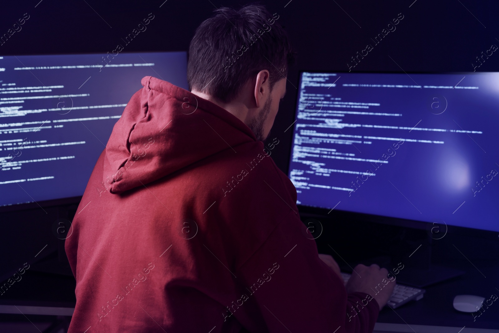 Photo of Hacker working with computers in dark room. Cyber attack