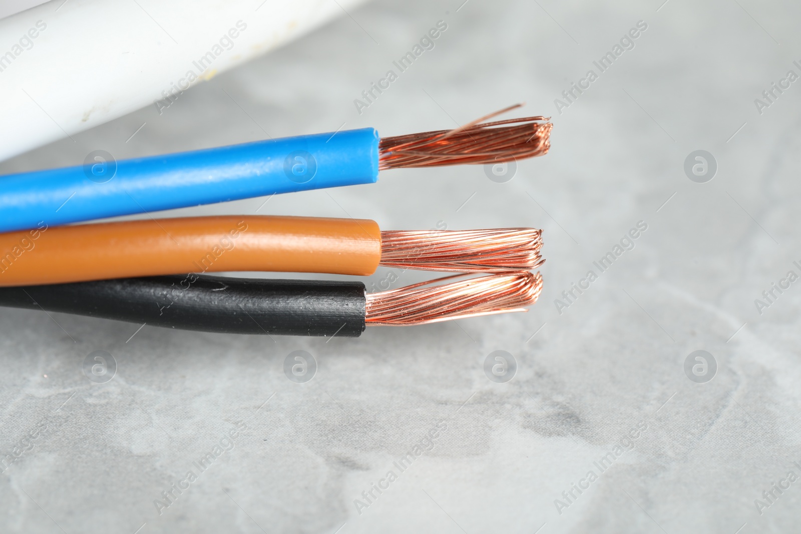 Photo of Colorful electrical wire on gray textured surface, closeup