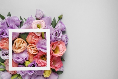 Photo of Flat lay composition with beautiful Eustoma flowers on grey background, space for text