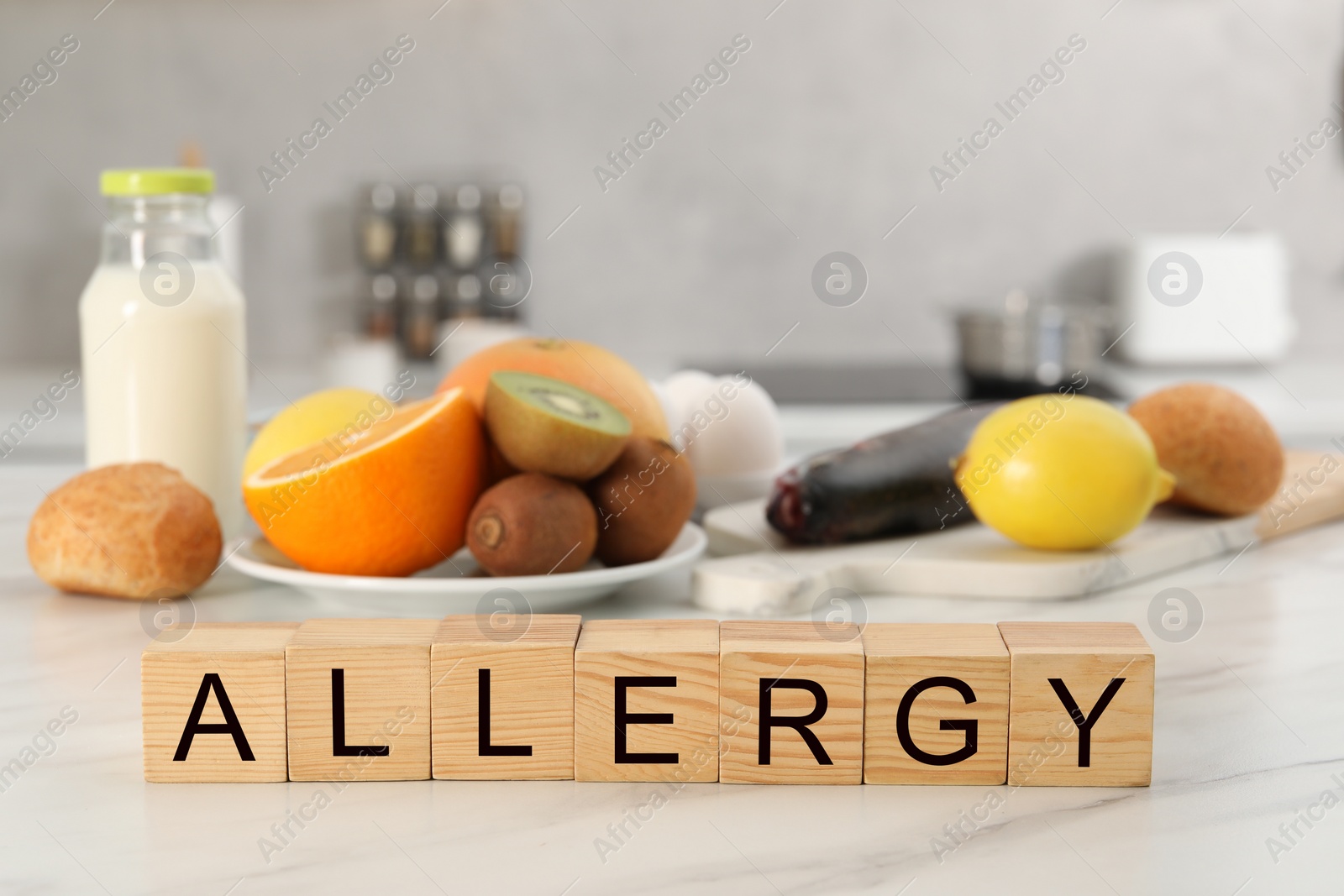 Image of Food allergy. Different fresh products and wooden cubes on white marble table