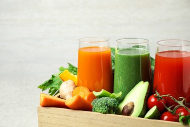Photo of Delicious vegetable juices and fresh ingredients on light background, closeup